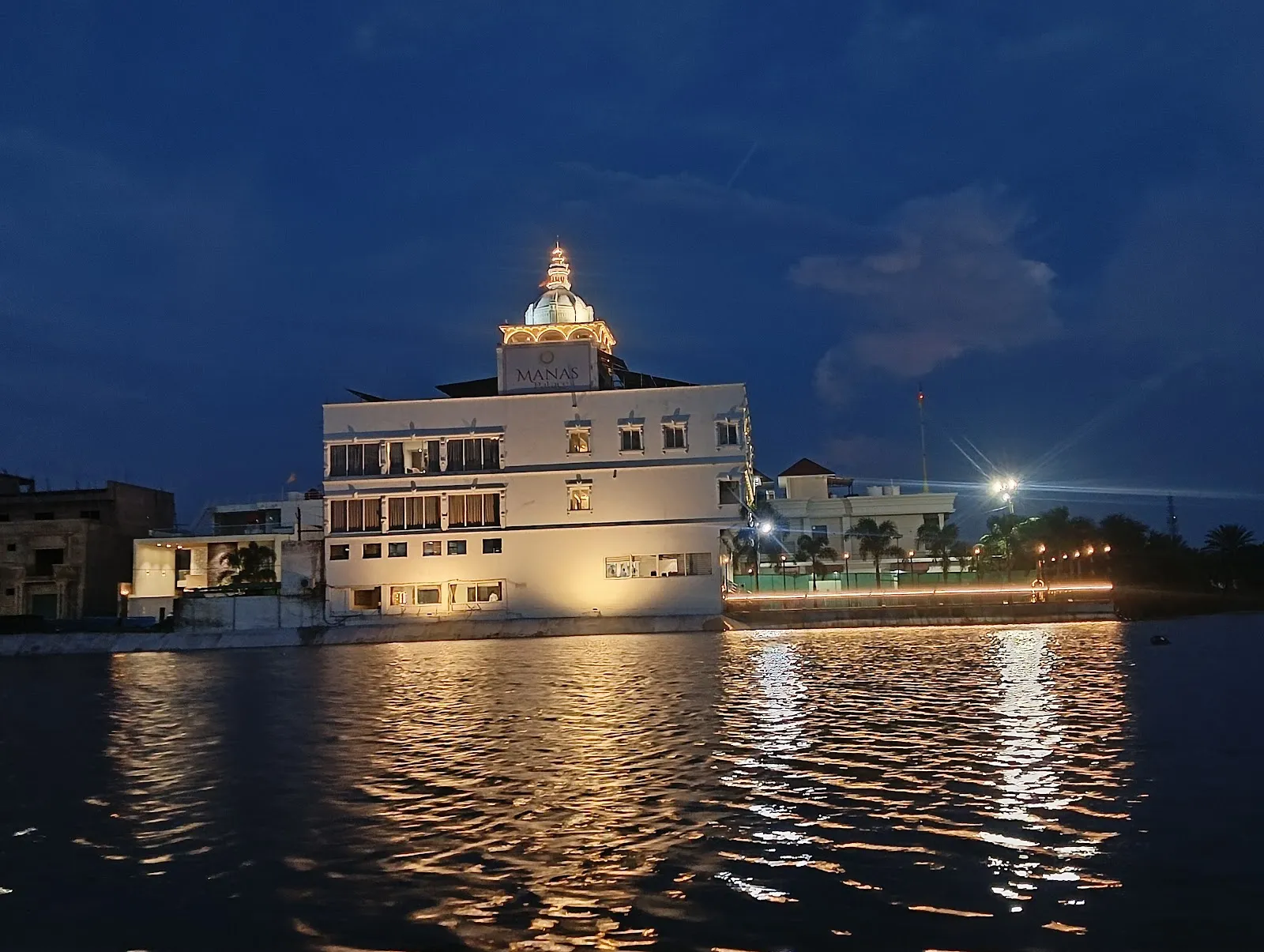 Hotel Manas Palace lit up beside the lake